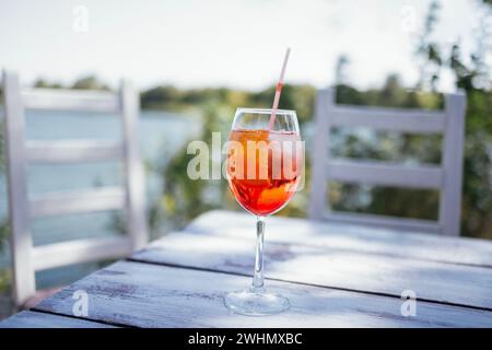 Élégant verre à longue tige de spritz aperol avec tranche d'orange sur table en bois blanc. Banque D'Images