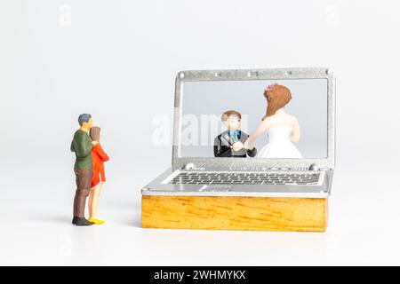 Mariage virtuel de mariée et marié de personnes miniatures sur écran d'ordinateur Banque D'Images