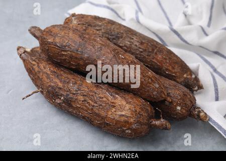 Racines de manioc entières fraîches sur table grise, gros plan Banque D'Images