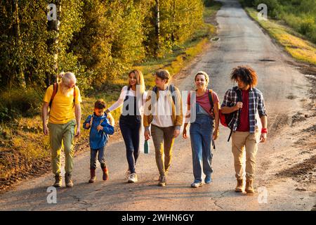 Amis en promenade dans la belle nature rurale dans un paysage derrière le village. Profiter d'une journée heureuse et amusante et de temps libre. Groupe de Banque D'Images