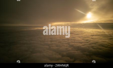 Le soleil brille par des rayons de lumière rayant à travers des nuages sombres sur la montagne au coucher du soleil.Ciel spectaculaire en hiver Banque D'Images