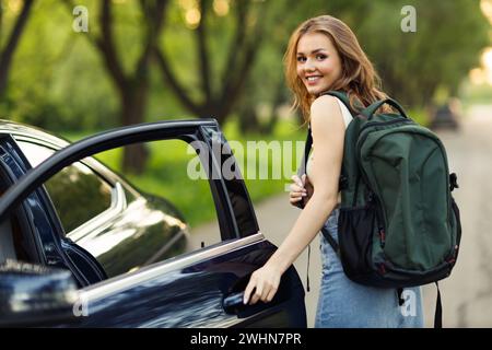 Femme heureuse conductrice à la voiture souriante. Mignonne jeune femme brune heureuse voiture de conduite. Banque D'Images