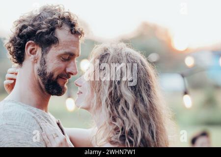 Concept de style de vie d'un beau jeune couple amoureux se séparant de leur groupe d'amis en arrière-plan ayant un plein air Banque D'Images