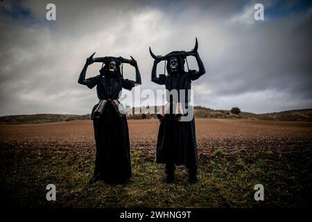 Madrid, Espagne. 10 février 2024. Un couple d'hommes caractérisés par des cornes et de la peinture noire sur leur corps participent aux festivités de Luçon. Une fois de plus, la ville de Luzon, près de Guadalajara en Castilla la Mancha, en Espagne, a célébré sa fête traditionnelle des diables de Luzon où certains habitants peignent leurs visages et s'habillent en noir et portent des cornes et des cloches tandis que d'autres couvrent leurs visages avec des masques blancs de genre. Le festival a plus de 50 ans. (Photo de David Canales/SOPA images/SIPA USA) crédit : SIPA USA/Alamy Live News Banque D'Images