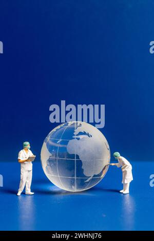 Le médecin et l'infirmière en miniature vérifiant les soins de santé mondiaux Banque D'Images