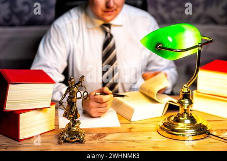 Bureau d'un avocat avec statue de Dame Justice, déesse Justitia, sur le bureau Banque D'Images