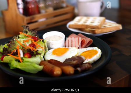 Petit déjeuner complet avec oeuf frit, saucisse, bacon, jambon, pain grillé et salade. Vue de dessus Banque D'Images
