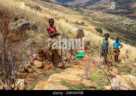Jeune fille et garçon locaux vendant des souvenirs debout dans un paysage montagneux. Andringitra, Madagascar Banque D'Images