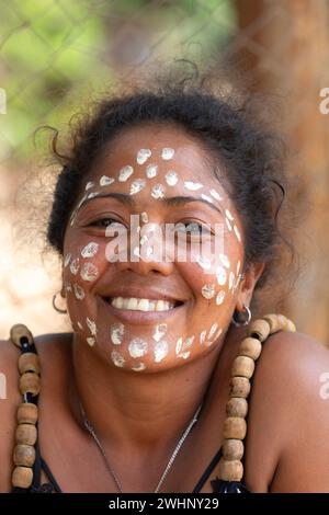 Gros plan portrait d'une femme malgache avec des points blancs peints sur son visage dans le cadre d'une culture traditionnelle. Banque D'Images