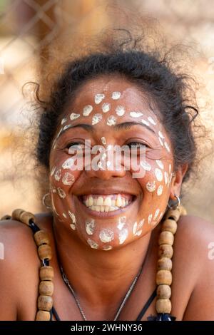 Gros plan portrait d'une femme malgache avec des points blancs peints sur son visage dans le cadre d'une culture traditionnelle. Banque D'Images