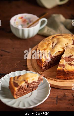 Tarte zèbre chocolat et vanille avec morceau coupé sur plaque. Gâteau au chocolat en marbre fait maison Banque D'Images