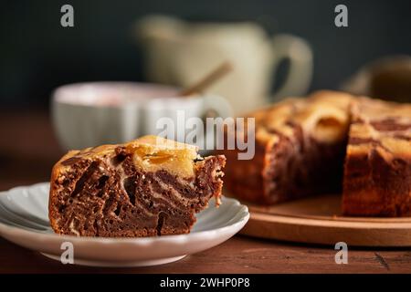 Tarte zèbre chocolat et vanille avec morceau coupé sur plaque. Gâteau au chocolat en marbre fait maison Banque D'Images