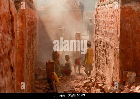 Narayanganj, Bangladesh. 10 février 2024. Des hommes bangladais travaillent dans un champ de briques à Narayanganj, Bangladesh, 10 février 2024. L'émission d'une énorme quantité d'éléments toxiques provenant des fours à briques entraîne de graves risques pour la santé des travailleurs et des personnes vivant dans les zones environnantes, la plupart souffrant de problèmes respiratoires ou cutanés. Les travailleurs dans ce domaine de la brique gagnent moins de 5 $ par jour. Photo de Suvra Kanti Das/ABACAPRESS.COM crédit : Abaca Press/Alamy Live News Banque D'Images