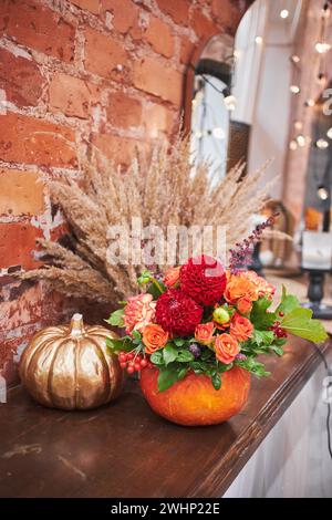 Bouquet d'automne dans un vase de citrouille. Beau décor floral pour Thanksgiving et halloween. Ambiance chaleureuse de la maison, décor d'automne. Banque D'Images