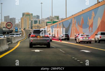 Trafic automobile sur une route d'autoroute avec gratte-ciel de construction en arrière-plan à Dubaï Émirats arabes Unis. Autoroute menant au centre-ville de Dubaï. Editorial, voyage ph Banque D'Images