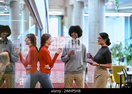 Au milieu des murs de verre modernes d'un bureau de démarrage, un groupe diversifié de collègues, y compris un homme afro-américain, s'engagent dans un Banque D'Images