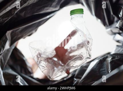 Image de l'intérieur du sac de recyclage jaune d'un homme jetant une bouteille en plastique vide dans un bac de recyclage Home recycle éco vert zéro concept Banque D'Images