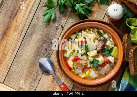 Soupe traditionnelle hongroise épaisse avec bœuf, légumes et boulettes sur une table en bois.Dîner chaud ou déjeuner.Flat lay, vue de dessus. Banque D'Images