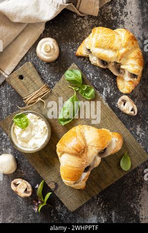 Croissant avec fromage à la crème et champignon sur un fond de pierre. Pâtisserie française, savoureux sandwich fraîchement cuit. Cuisine végétalienne. V Banque D'Images