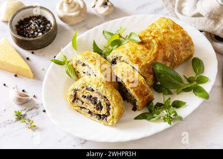 Nourriture végétarienne délicieuse. Rouleau de courgettes (roulade) avec fromage et champignons sur un plateau en marbre. Banque D'Images