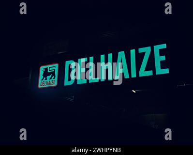 Bruxelles, Belgique. 6 février 2024. Logo d'un supermarché Delhaize. Rues de Bruxelles. Ville de nuit. Banque D'Images