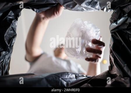 Image de l'intérieur du sac de recyclage jaune d'un homme jetant une bouteille en plastique vide dans un bac de recyclage Home recycle éco vert zéro concept Banque D'Images