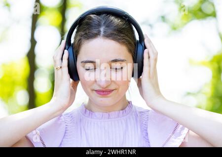 Connexion musicale intense : jeune femme dans la nature sereine Banque D'Images