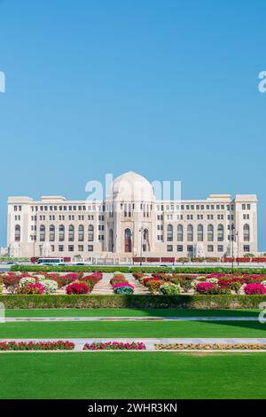 Vue de face à la Cour suprême d'Oman à Muscat, Oman. Jardins de jour ensoleillés au premier plan. Banque D'Images