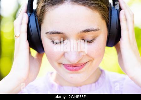 Connexion musicale intense : jeune femme dans la nature sereine Banque D'Images