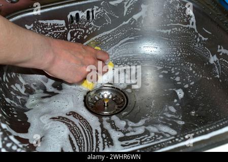 Gros plan des mains d'une femme, lavant la surface de l'évier avec mon gant de toilette. Photo de haute qualité Banque D'Images