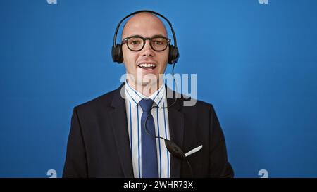 Jeune homme hispanique employé d'affaires portant un casque sur fond bleu isolé Banque D'Images