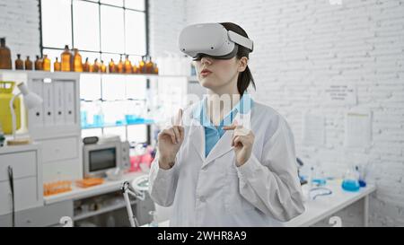 Une jeune femme caucasienne portant des lunettes de réalité virtuelle dans un laboratoire moderne, véhiculant l'innovation dans la science. Banque D'Images