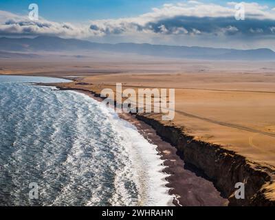 Vue panoramique sur le désert dans la réserve nationale de Paracas avec la célèbre plage Rouge au premier plan, région d'ICA, Pérou Banque D'Images