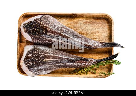 Monkfish frais sans tête sur un plateau en bois isolé sur fond blanc. Vue de dessus Banque D'Images