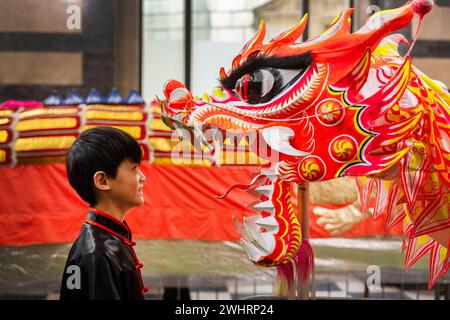 USAGE ÉDITORIAL EXCLUSIF Vincent Hong, 11 ans, de Manchester, regarde de près un dragon avant de participer à la parade du Dragon dans le cadre des célébrations du nouvel an chinois à Manchester pour accueillir l'année du Dragon. Date de la photo : dimanche 11 février 2024. Banque D'Images