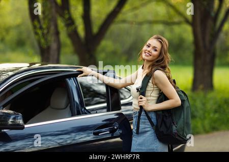 Femme heureuse conductrice à la voiture souriante. Mignonne jeune femme brune heureuse voiture de conduite. Banque D'Images