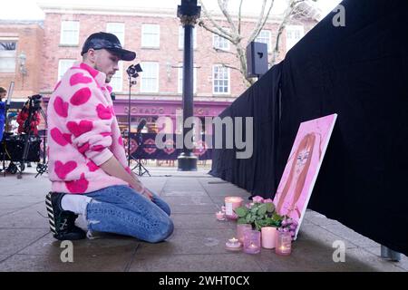 Sam Small, laisse quelques fleurs à côté d'une peinture qu'il a faite de Brianna Ghey, 16 ans assassinée, alors qu'il assiste à une veillée à Golden Square, Warrington, pour marquer le premier anniversaire de sa mort. Date de la photo : dimanche 11 février 2024. Banque D'Images