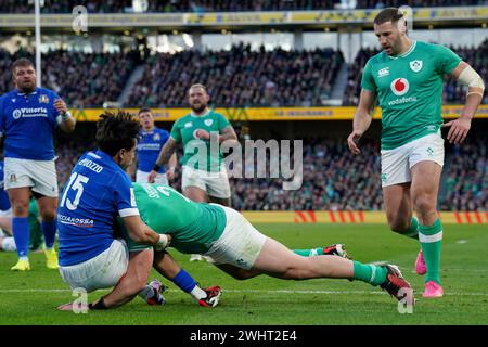 L'irlandais Dan Sheehan (au centre) marque son deuxième essai malgré les efforts de l'Italien Ange Capuozzo (à gauche) pour l'arrêter lors du match des six Nations Guinness au stade Aviva de Dublin, en Irlande. Date de la photo : dimanche 11 février 2024. Banque D'Images