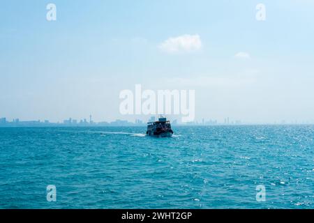 Paysage marin avec des navires à passagers venant à la jetée, vue arrière de la ville de Pattaya, Thaïlande Banque D'Images