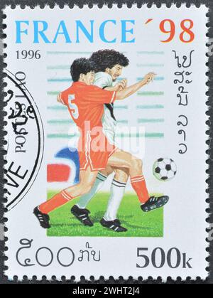 Timbre-poste oblitéré imprimé par le Laos, qui promeut le football, Coupe du monde de la FIFA, France -1998, circa 1996. Banque D'Images
