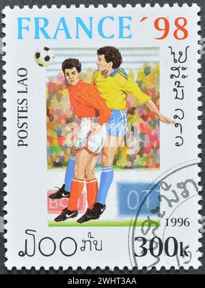 Timbre-poste oblitéré imprimé par le Laos, qui promeut le football, Coupe du monde de la FIFA, France -1998, circa 1996. Banque D'Images