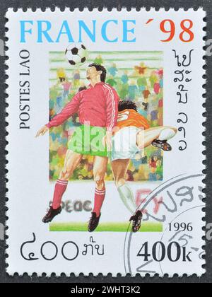 Timbre-poste oblitéré imprimé par le Laos, qui promeut le football, Coupe du monde de la FIFA, France -1998, circa 1996. Banque D'Images