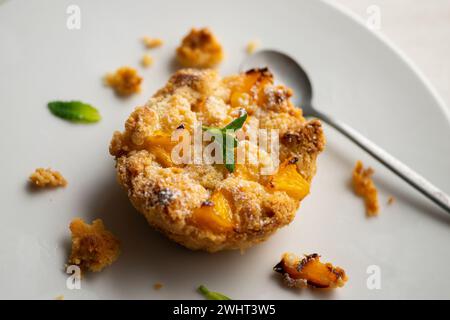 Tartelette de crumble de pêche dans une pâtisserie française à Paris. Banque D'Images