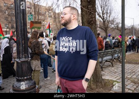 Brooklyn, États-Unis. 10 février 2024. NEW YORK, NEW YORK - 10 FÉVRIER : un homme portant un sweat-shirt « Nice Jewish Boy » regarde une marche pro-palestinienne appelant à un cessez-le-feu permanent et à un soutien aux Palestiniens lors d'un rassemblement devant le Brooklyn Museum of Art le 10 février 2024 à New York. Le ministère de la santé de Gaza a déclaré que le nombre de morts a dépassé les 30 000 personnes, dont environ les deux tiers étaient des femmes et des enfants, depuis le début du conflit israélo-Hamas le 7 octobre 2023. (Photo de Michael Nigro/Sipa USA) crédit : Sipa USA/Alamy Live News Banque D'Images