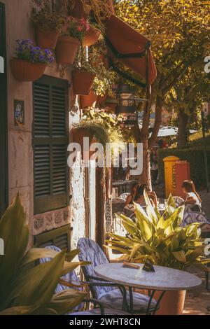 Les gens se sont assis dans un café en plein air par une journée ensoleillée à Valldemossa, Espagne Banque D'Images