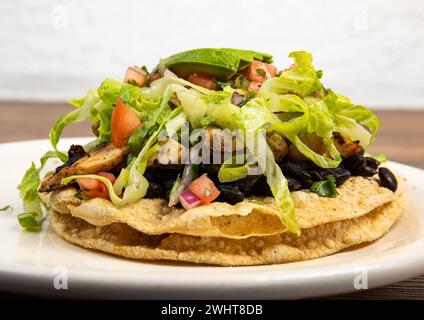 Un délicieux sandwich frit à l'air avec des légumes frais servi sur une assiette blanche Banque D'Images