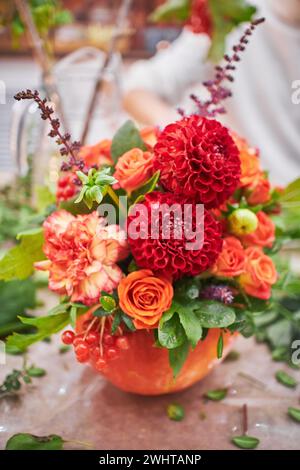 Master class sur la fabrication de bouquets. Bouquet d'automne dans une citrouille. Arrangements floraux, créant de beaux bouquets avec votre propre han Banque D'Images