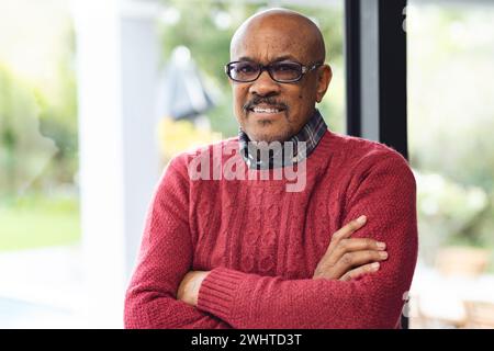 Portrait d'homme biracial senior heureux portant des lunettes souriant à la maison Banque D'Images