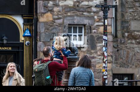 Touriste touchant le nez de la statue de chien Bobby de Greyfriar pour bonne chance, Édimbourg, Écosse, Royaume-Uni Banque D'Images