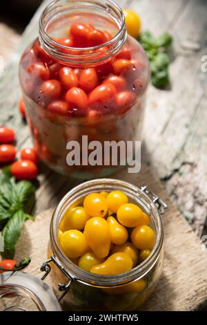 Tomates cerises rouges et jaunes dans un bocal pour l'hiver Banque D'Images